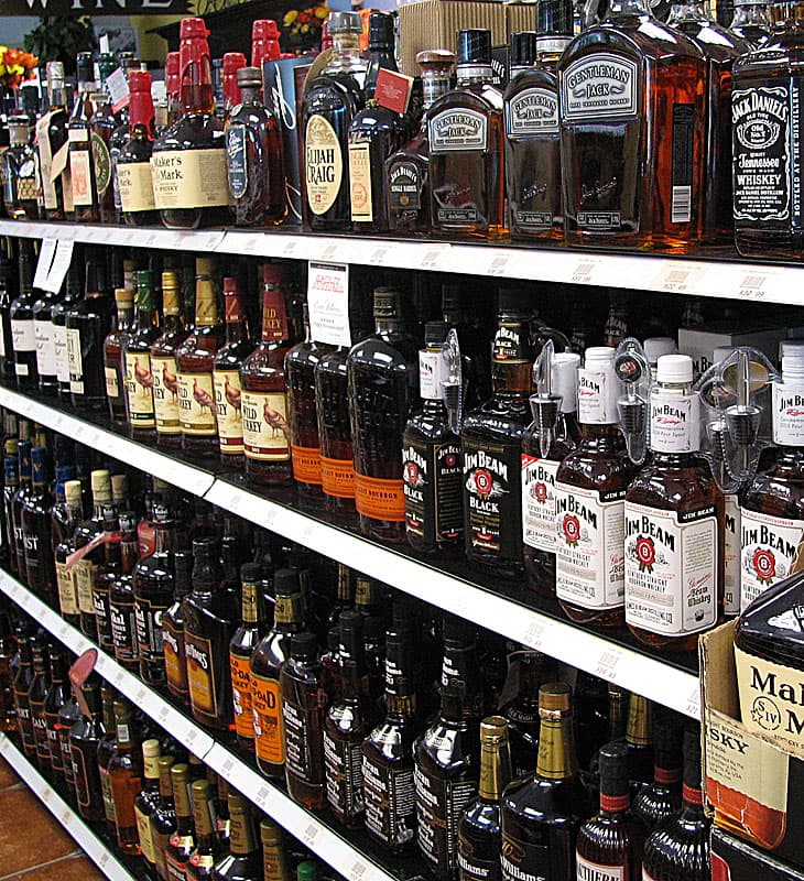 Bourbon bottles including Maker’s Mark, Bulleit and Jim Beam on whiskey shop shelves